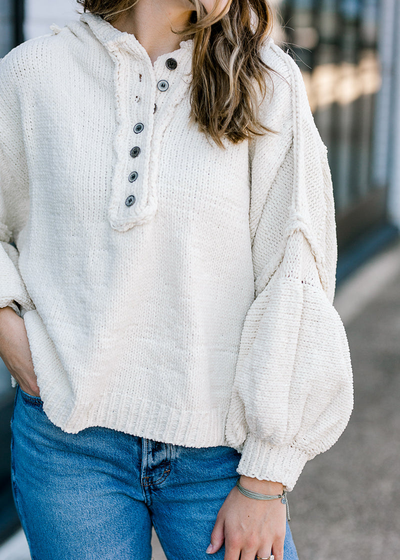 Close up view of buttons on ivory sweater.