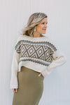Blonde model wearing a cream, long sleeve sweater with a crop hem.