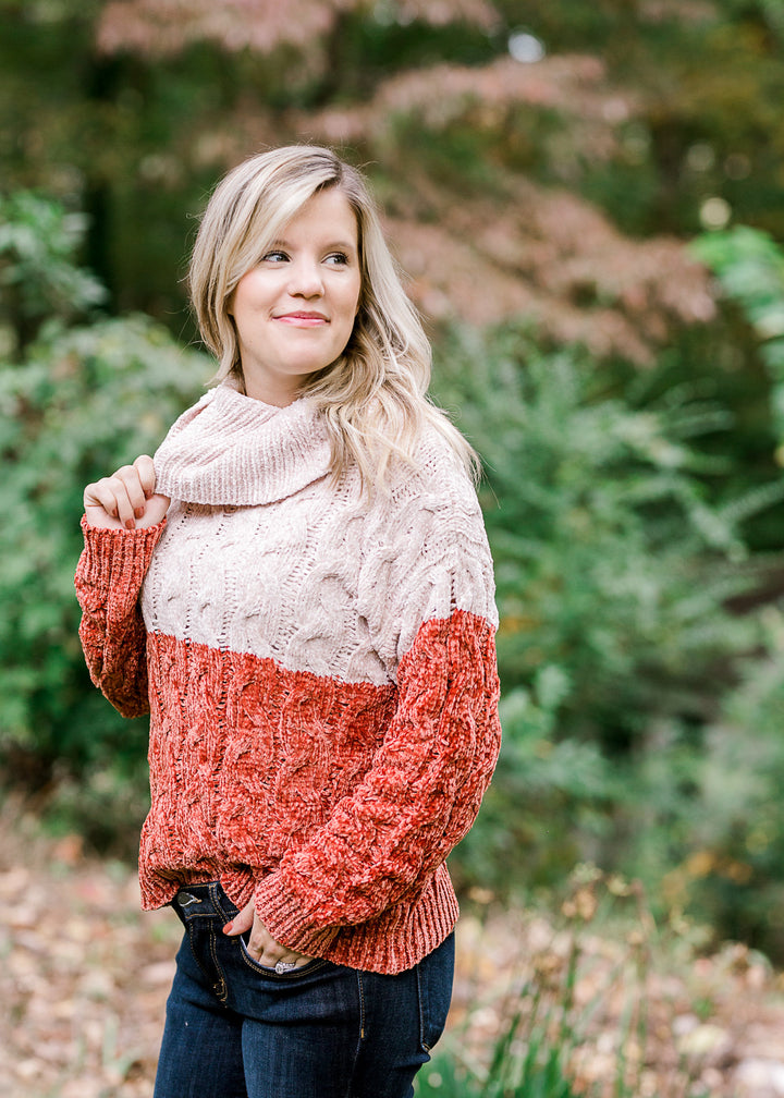 Blonde model wearing ivory and rust sweater. 