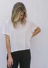 Blonde model wearing ivory slightly cropped tee.