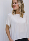 Close up of Blonde model wearing ivory slightly cropped tee.