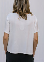 Back view of Blonde model wearing ivory slightly cropped tee.