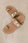 Brown sandal with jewel embellished strap and toe loop and embossed sole.