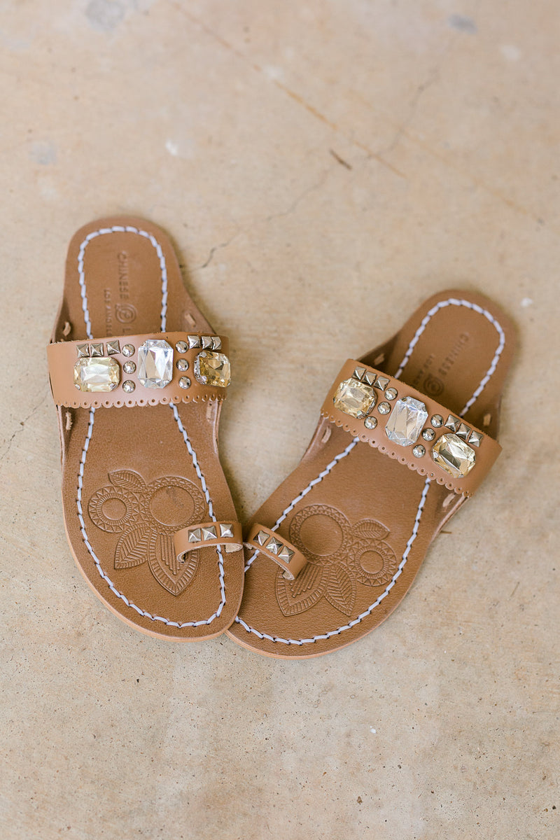 Brown sandal with jewel embellished strap and toe loop fits tts.