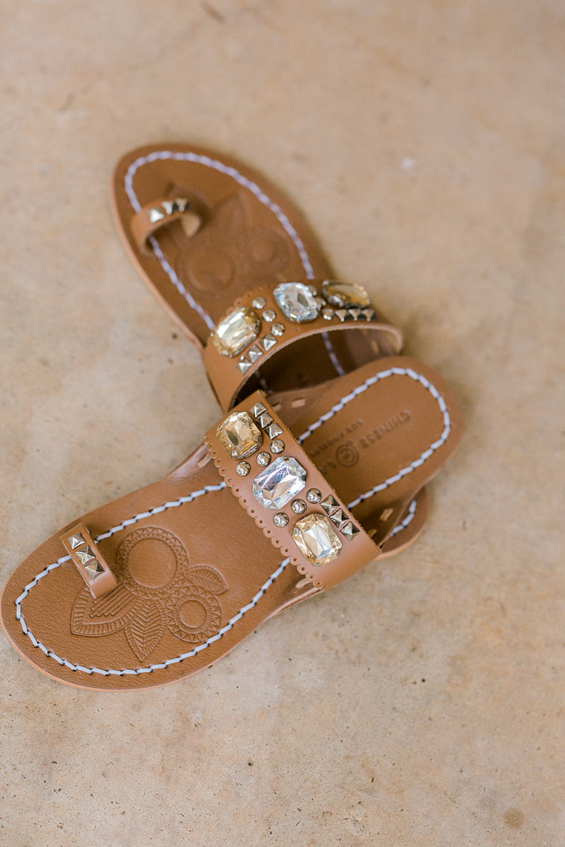 Brown sandal with jewel embellished strap and toe loop.