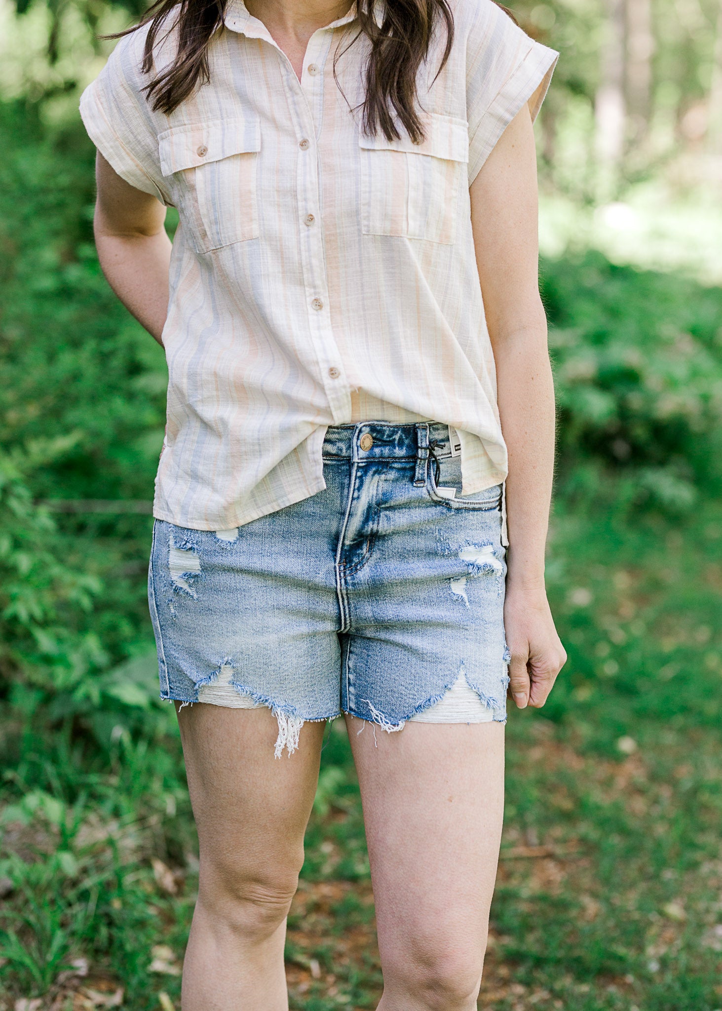 Judy Blue destroyed denim shorts on  brunette model.