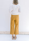 Back view of Model wearing marigold wide leg cropped jeans with back pockets. 