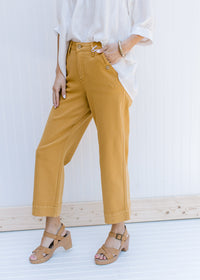 Model wearing marigold wide leg cropped jeans with button on front pockets. 