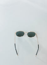 Back view of round sunglasses with gold rim. 