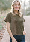 Blonde model wearing black and gold top.