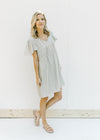 Model wearing a mint colored babydoll dress with flutter short sleeves and a ruffle at the waist. 