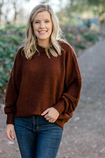 Blonde model wearing a wine colored sweater. 