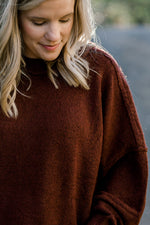 Close up of Blonde model wearing a wine colored sweater.