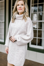 Close up of Blonde model wearing ivory sweater dress.