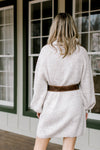 Back view of Blonde model wearing ivory sweater dress.