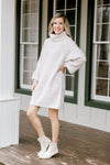 Blonde model wearing ivory sweater dress without belt.