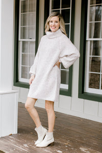 Blonde model wearing ivory sweater dress without belt.
