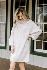 Close up of Blonde model wearing ivory sweater dress without belt.