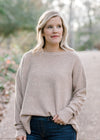 Blonde model wearing ribbed cream sweater. 
