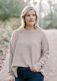 Blonde model wearing ribbed cream sweater. 
