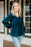 Blonde model wearing a navy babydoll top.