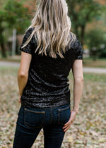Back view of Blonde model wearing short sleeve black sequin jacket.
