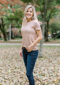 Blonde model wearing rose gold sequin top with short sleeves.