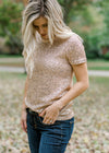 Close up of Blonde model wearing rose gold sequin top with short sleeves.