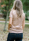 back view of Blonde model wearing rose gold sequin top with short sleeves.