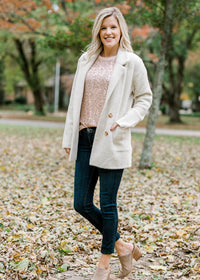 Blonde model wearing rose gold sequin top and jacket.