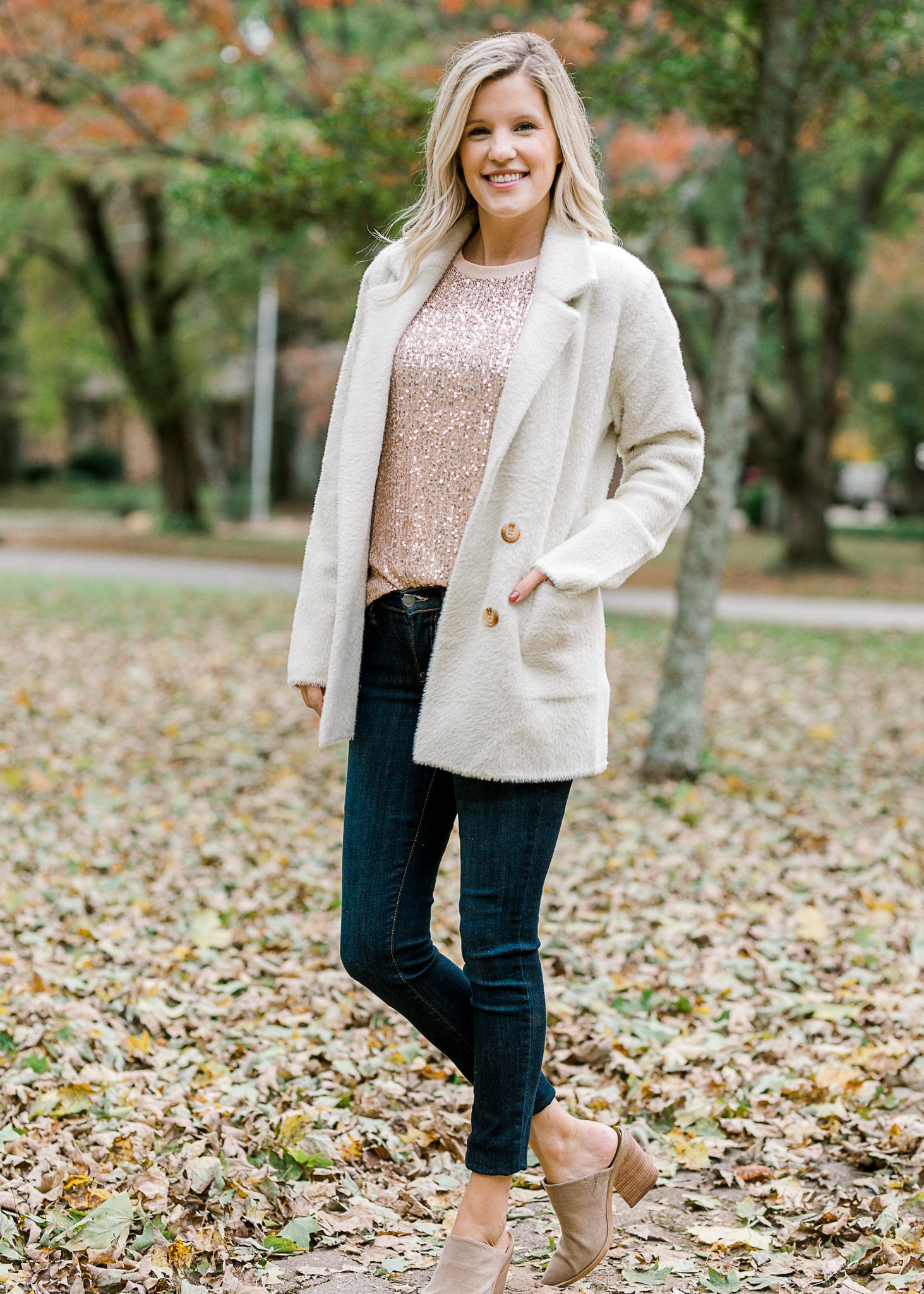 Blonde model wearing rose gold sequin top and jacket.