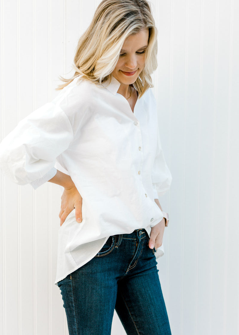 Blonde model wearing a white button up. 