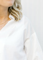 Close up view of collar on white blouse. 