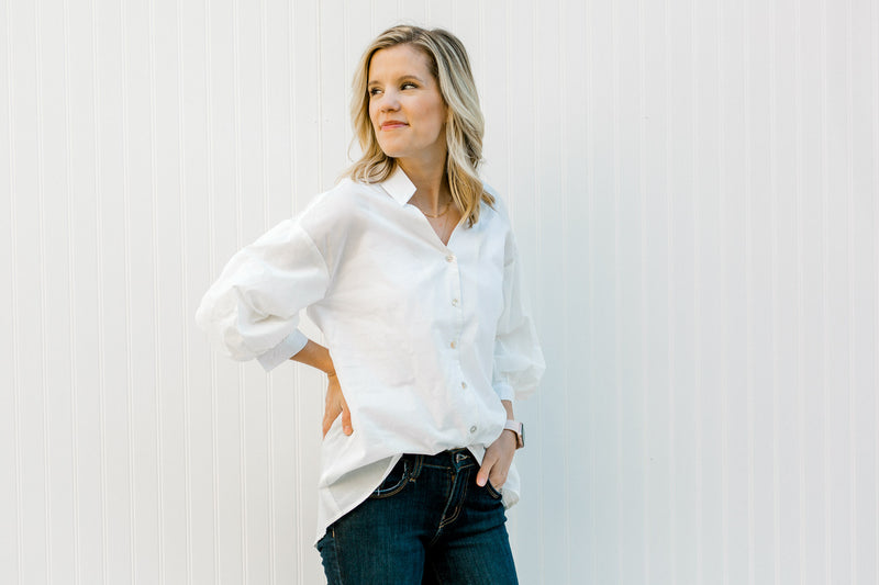 Blonde model wearing a white button up with jeans. 