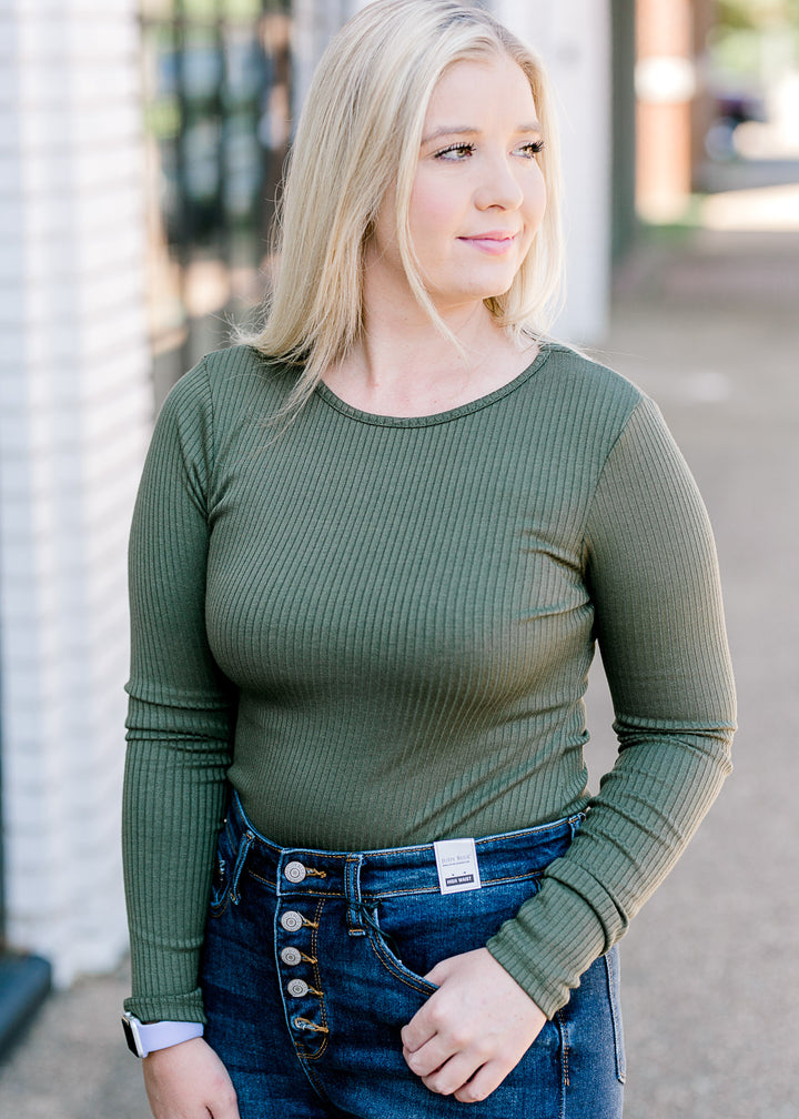 Blonde model wearing olive bodysuit. 