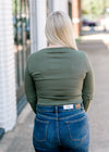 Back view of Blonde model wearing olive bodysuit.