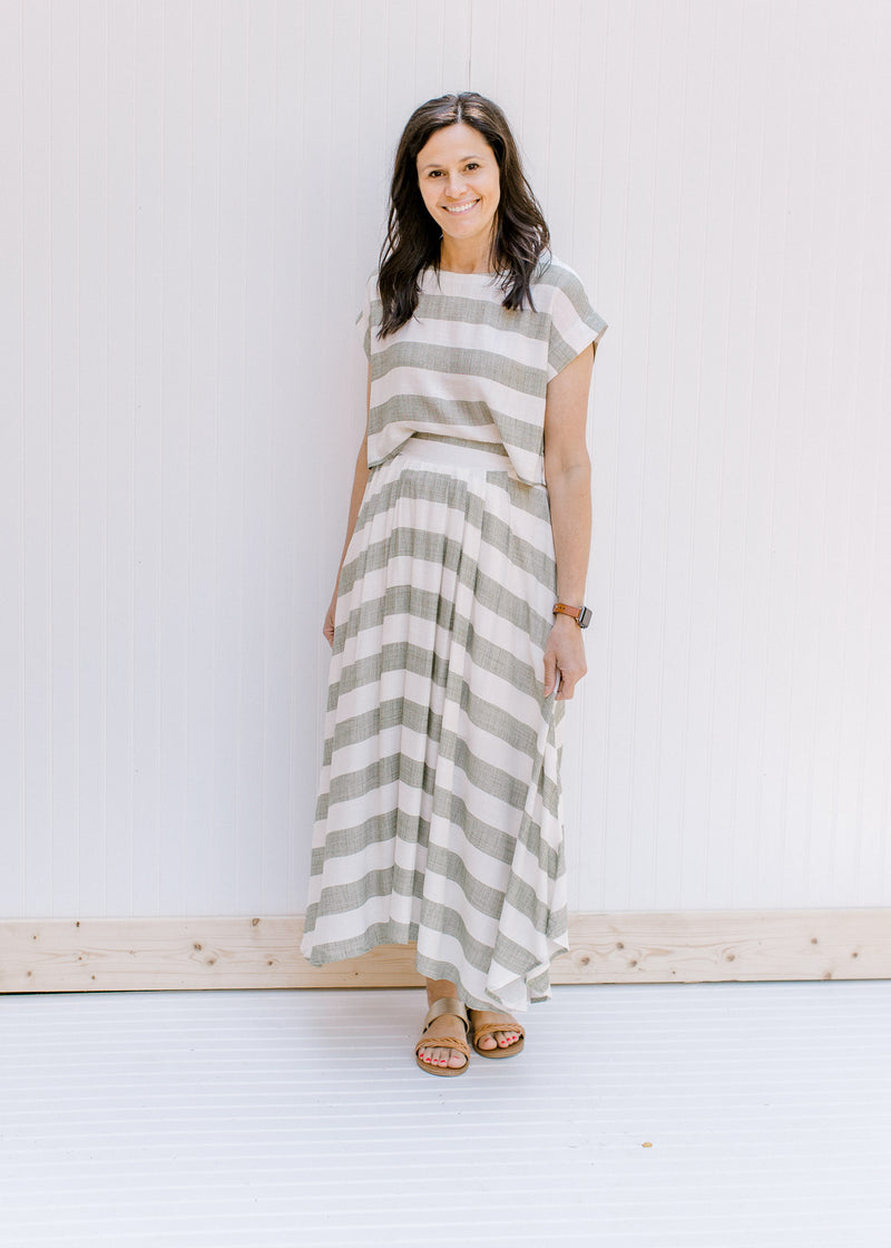 Model wearing a olive and cream crop top with a matching maxi skirt with an elastic waistband. 