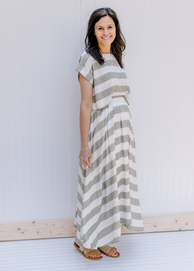 Model wearing a olive and cream striped crop top with short sleeves and a matching maxi skirt.