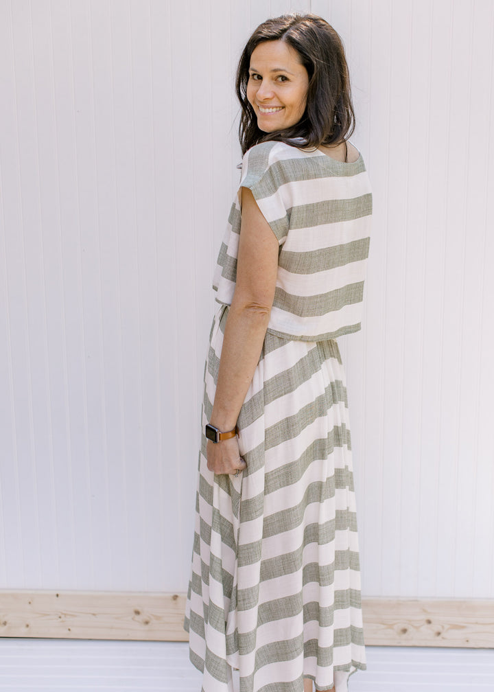 Back view of Model wearing a olive and cream striped crop top with short sleeves.