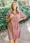 Blonde model wearing purple button up corduroy dress With pockets.