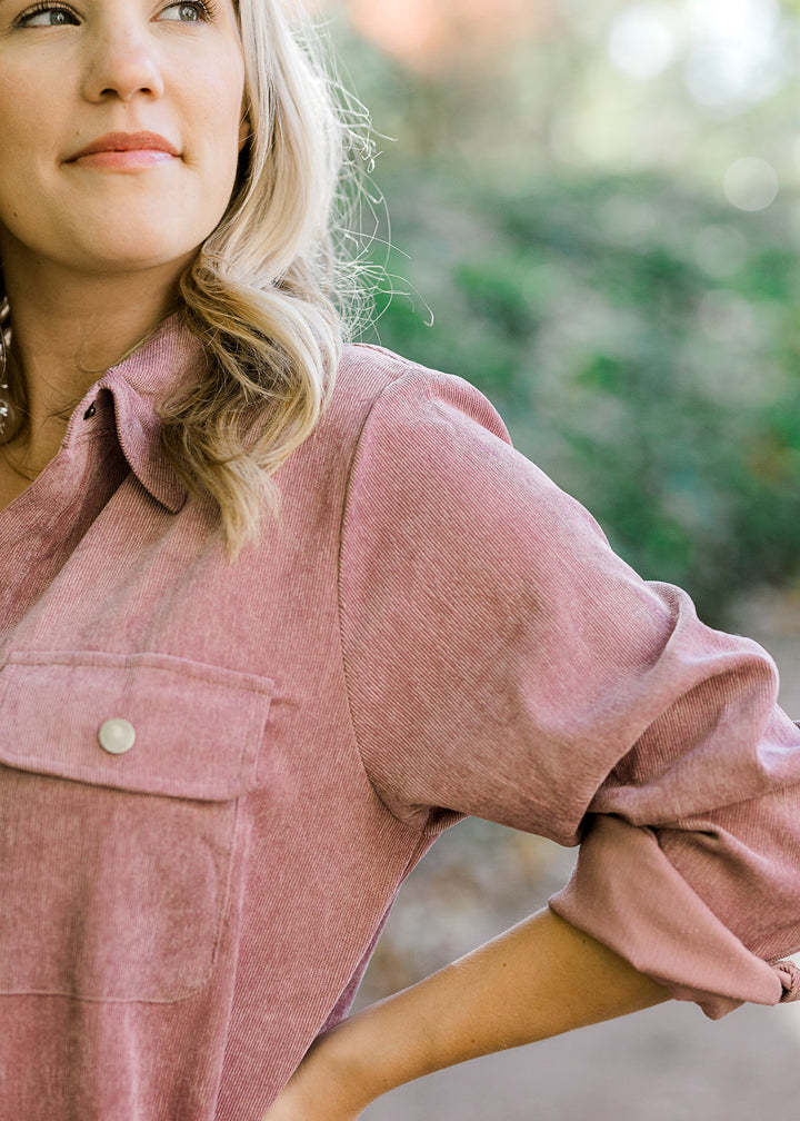 Close up view of Blonde model wearing purple button up corduroy dress