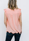 Back view of Blonde model wearing peach top with rust embroidery.