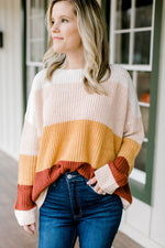 Blonde model wearing a color block sweater. 