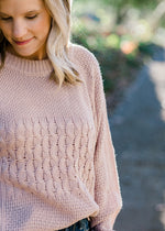 Close up of cable knit design on pearl sweater. 