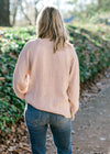 Back view of Blonde model wearing pearl sweater. 