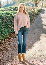Blonde model wearing pearl sweater with jeans and booties.