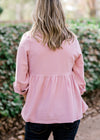 Back view of Blonde model wearing a pink corduroy button up top.  