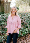 Blonde model wearing a pink corduroy button up top.  