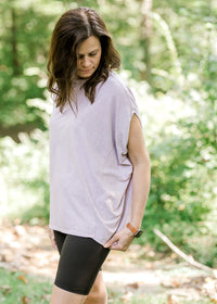 Brunette model wearing pink workout shirt and bike shorts.