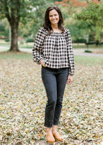 Brunette model wearing cream and black plaid top with bubble long sleeves.